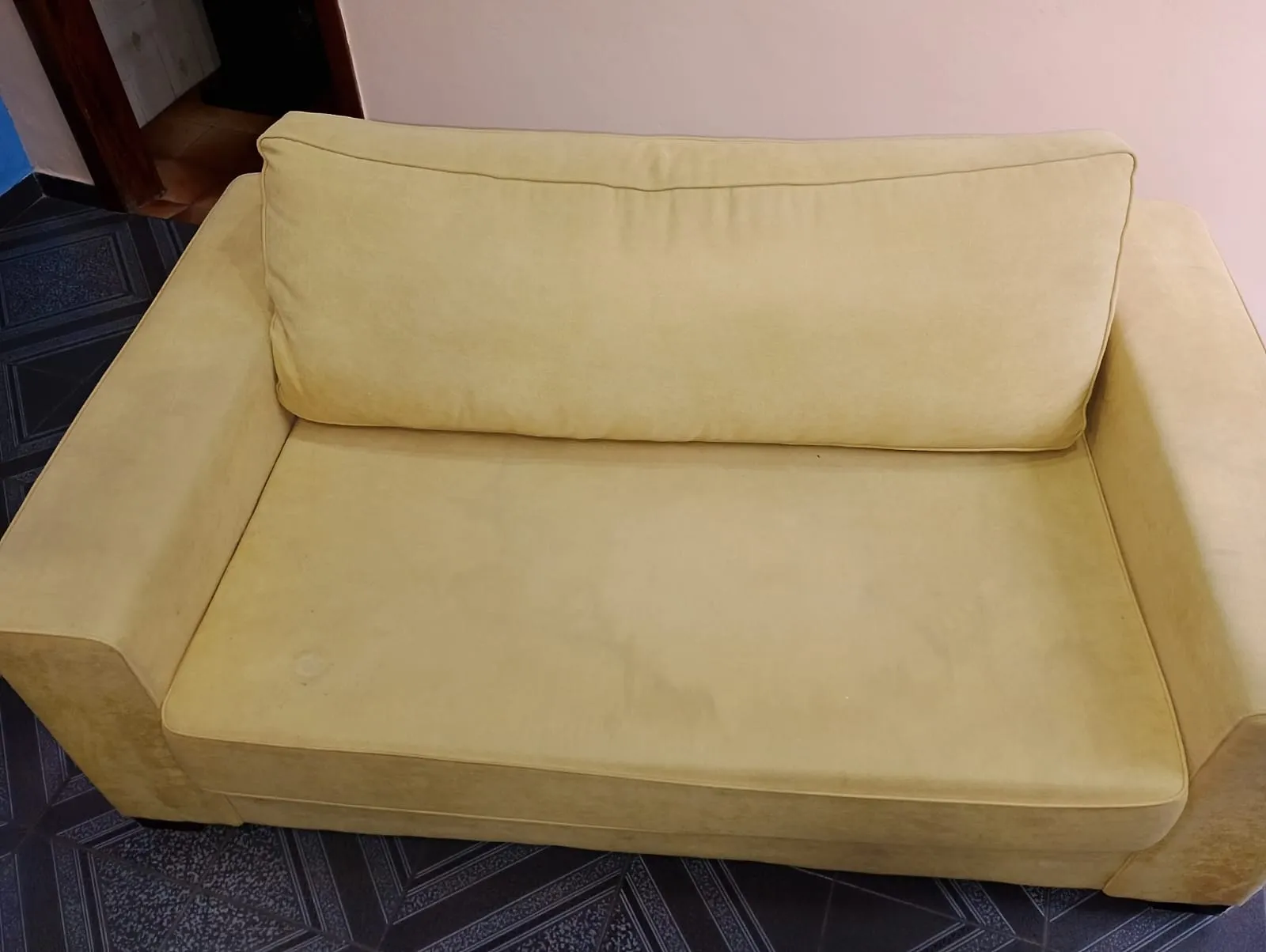 Sofá amarelo depois da higienização, com cor revitalizada e tecido limpo